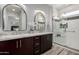 This bathroom features a double vanity with granite counters, modern lighting, and glass shower at 16476 W Limestone Dr, Surprise, AZ 85374