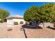 Well-manicured landscaping surrounds this single-story home with a two-car garage at 16476 W Limestone Dr, Surprise, AZ 85374
