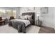 This main bedroom boasts hardwood floors, a plush bed with a tufted headboard, and art at 16476 W Limestone Dr, Surprise, AZ 85374