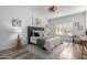 This main bedroom boasts wood floors, a plush bed with a tufted headboard, and art at 16476 W Limestone Dr, Surprise, AZ 85374