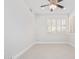 An empty bedroom with neutral walls, tile floors, a ceiling fan, and a window with white shutters at 17816 W Mariposa Dr, Surprise, AZ 85374