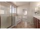 Bathroom with walk-in shower, tub, neutral color scheme, and a door leading to a walk-in closet at 18060 W Rimrock St, Surprise, AZ 85388