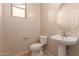 Well-lit powder room features a pedestal sink and a neutral color palette at 18060 W Rimrock St, Surprise, AZ 85388