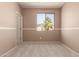 Unfurnished bedroom features neutral carpet and walls and a large window at 18060 W Rimrock St, Surprise, AZ 85388