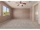 Bedroom boasts neutral paint, carpet, and a ceiling fan at 18060 W Rimrock St, Surprise, AZ 85388