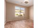 A simple unfurnished room features hardwood floors, a neutral paint palette, and a window overlooking the yard at 18060 W Rimrock St, Surprise, AZ 85388