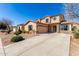 Two-story home featuring a three-car garage, desert landscaping, and beautiful stone accents at 18060 W Rimrock St, Surprise, AZ 85388