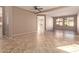 Open-concept living room with neutral paint, tile flooring, and large windows at 18060 W Rimrock St, Surprise, AZ 85388