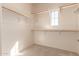 Spacious walk-in closet features carpet, a small window, and ample shelving and clothing racks at 18060 W Rimrock St, Surprise, AZ 85388