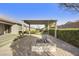 Secluded backyard features an open air pergola, built in fire pit, artificial lawn and privacy landscaping at 19235 E Peartree Ln, Queen Creek, AZ 85142