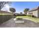 Beautiful outdoor space with a fire pit, manicured hedges, and lush green grass at 19235 E Peartree Ln, Queen Creek, AZ 85142