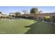 Well-manicured backyard features a pergola, fire pit, and low-maintenance artificial turf at 19235 E Peartree Ln, Queen Creek, AZ 85142