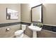 Stylish powder room with pedestal sink, tile accents, and decorative mirror at 19235 E Peartree Ln, Queen Creek, AZ 85142