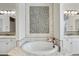 Elegant bathroom features a soaking tub, dual sinks, and decorative tile accents at 19235 E Peartree Ln, Queen Creek, AZ 85142