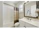 Bright bathroom with a white vanity, decorative mirror, neutral walls, and a shower-tub with curtain at 19235 E Peartree Ln, Queen Creek, AZ 85142