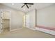Carpeted bedroom featuring a ceiling fan, neutral-colored walls, built-in seating, and a walk-in closet at 19235 E Peartree Ln, Queen Creek, AZ 85142