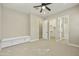 Spacious bedroom with carpet flooring, ceiling fan, built-in seating, walk-in closet, and an en-suite bathroom at 19235 E Peartree Ln, Queen Creek, AZ 85142