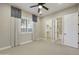 Spacious bedroom with a fan, neutral carpet, and access to en-suite bathroom and closet at 19235 E Peartree Ln, Queen Creek, AZ 85142