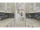 Chic butler's pantry featuring custom cabinetry and decorative backsplash, leading to the dining area at 19235 E Peartree Ln, Queen Creek, AZ 85142