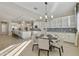 Breakfast nook with modern chandelier and view into kitchen with granite island and stainless appliances at 19235 E Peartree Ln, Queen Creek, AZ 85142