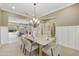 Elegant dining room with a modern chandelier and a view of the living area and backyard at 19235 E Peartree Ln, Queen Creek, AZ 85142