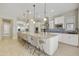 Bright, open kitchen with large island, white cabinets, stainless appliances and adjacent breakfast nook at 19235 E Peartree Ln, Queen Creek, AZ 85142