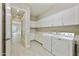 Functional laundry room with ample cabinetry and counter space, plus a modern washer and dryer at 19235 E Peartree Ln, Queen Creek, AZ 85142