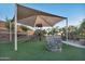 Community playground with shade structure, slide, climbing features, and picnic area at 19235 E Peartree Ln, Queen Creek, AZ 85142