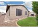 A landscaped backyard featuring a grass lawn, a rock garden, and a stucco privacy wall at 20529 N 94Th Ln, Peoria, AZ 85382