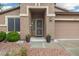 Inviting front entrance showcasing a security door, potted plants, and well-maintained desert landscaping at 20529 N 94Th Ln, Peoria, AZ 85382