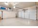 Clean garage featuring epoxy flooring, overhead storage shelf, and a well-maintained garage door at 20529 N 94Th Ln, Peoria, AZ 85382