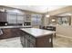 Well-lit kitchen with dark cabinets, tile floors, and a breakfast bar at 20529 N 94Th Ln, Peoria, AZ 85382