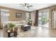 Spacious living room featuring a ceiling fan and sliding doors leading to the backyard patio at 20529 N 94Th Ln, Peoria, AZ 85382
