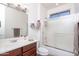 Bathroom with a white sink on a brown cabinet and a shower with a glass door at 21730 N Black Bear Lodge Dr, Surprise, AZ 85387