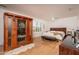 This bedroom has a light-colored wooden floor, a sauna, and a large bed in front of shuttered windows at 21730 N Black Bear Lodge Dr, Surprise, AZ 85387