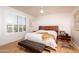 A bright bedroom with light-colored wooden floors and a large bed in front of shuttered windows at 21730 N Black Bear Lodge Dr, Surprise, AZ 85387