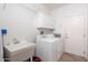 Functional laundry room with white appliances, sink, and plenty of storage space at 21730 N Black Bear Lodge Dr, Surprise, AZ 85387