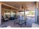 Spacious covered patio with comfortable seating, ceiling fans, and outdoor entertaining space at 21730 N Black Bear Lodge Dr, Surprise, AZ 85387