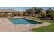 Inviting pool with brick trim, manicured lawn, and professional landscaping at 21730 N Black Bear Lodge Dr, Surprise, AZ 85387