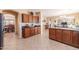 Kitchen with dark wood cabinetry, granite countertops, stainless steel appliances, and open access to living spaces at 2211 W Desert Ln, Phoenix, AZ 85041