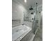 Elegant bathroom showcasing a bathtub, shower, and marble-style tiling at 2212 W Alicia Dr, Phoenix, AZ 85041