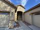 Inviting front entrance with dual garage doors and an arched entryway, protected by a home security system at 2212 W Alicia Dr, Phoenix, AZ 85041