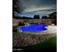 Inviting in-ground pool with rock waterfall feature, surrounded by mature landscaping and a cozy firepit area for outdoor relaxation at 2212 W Alicia Dr, Phoenix, AZ 85041
