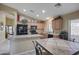 Modern kitchen with granite counters, island, black appliances, and adjacent dining area at 22177 E Calle De Flores --, Queen Creek, AZ 85142