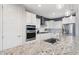 A well lit modern kitchen featuring white cabinets, stainless appliances, granite countertops, and pendant lighting above the central island at 25297 N 163Rd Dr, Surprise, AZ 85387