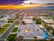 A sunset aerial view of the home and neighborhood featuring manicured lawns and multiple houses with pools at 2656 E Oriole Dr, Gilbert, AZ 85297
