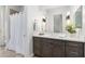 Well-lit bathroom featuring dark wood cabinetry, a spacious countertop, and decorative sconces at 2656 E Oriole Dr, Gilbert, AZ 85297