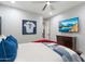 Comfortable bedroom with sports memorabilia, ceiling fan, and wood-look floors at 2656 E Oriole Dr, Gilbert, AZ 85297