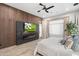 Modern primary bedroom with accent wall, sleek electric fireplace, and golf on TV at 2656 E Oriole Dr, Gilbert, AZ 85297