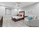 Cozy bedroom with a wooden bed frame, ceiling fan, and adjacent sitting area at 2656 E Oriole Dr, Gilbert, AZ 85297